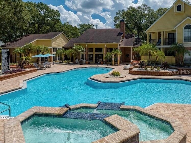 view of swimming pool with a patio area and a pool with connected hot tub