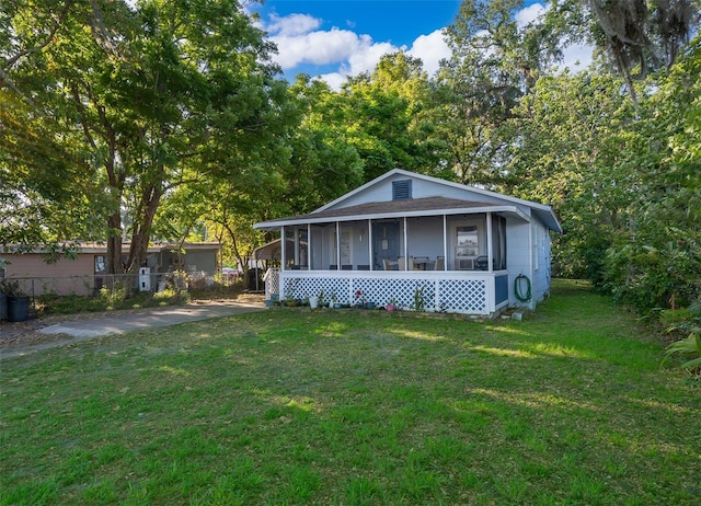 1204 34th St, Orlando, FL 32805 - view of front of home featuring a front yard, fence, and a sunroom