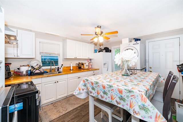 1204 34th St, Orlando, FL 32805 - kitchen featuring washer / clothes dryer, white refrigerator with ice dispenser, white cabinets, black range with electric cooktop, and a sink