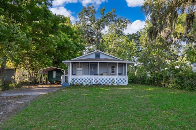 1204 34th St, Orlando, FL 32805 - bungalow-style home with driveway, a detached carport, a sunroom, and a front lawn