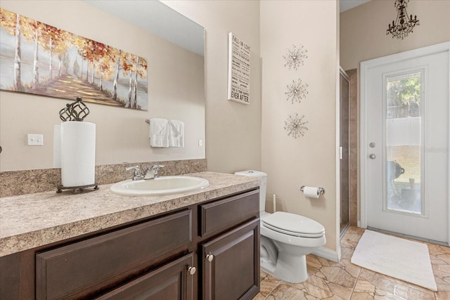 full bath featuring toilet, a stall shower, vanity, and baseboards