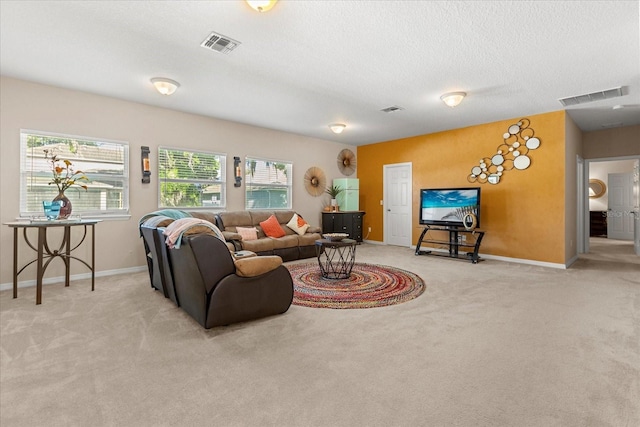living area with light carpet, visible vents, and a textured ceiling