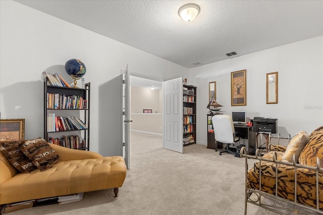 office with visible vents, a textured ceiling, and carpet floors