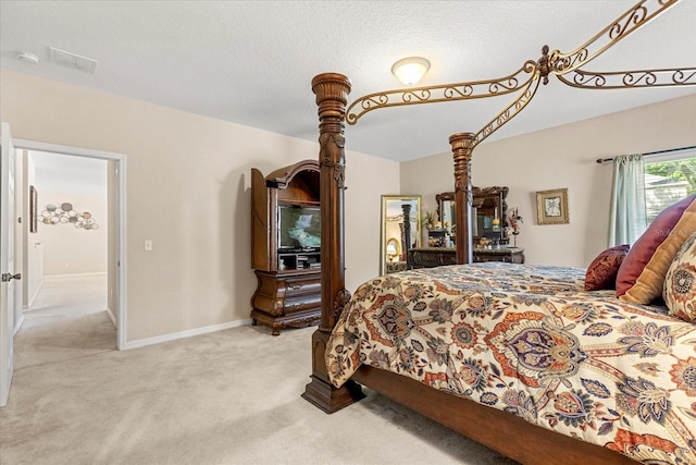 bedroom featuring light carpet, baseboards, and a textured ceiling