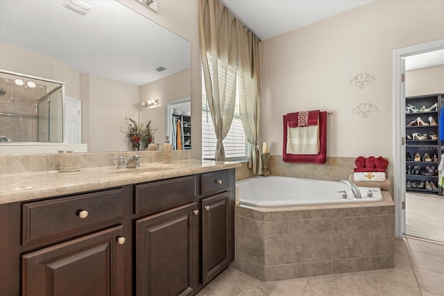 bathroom featuring visible vents, a bath, a shower stall, vanity, and tile patterned flooring