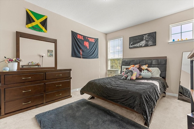 bedroom with light carpet and baseboards
