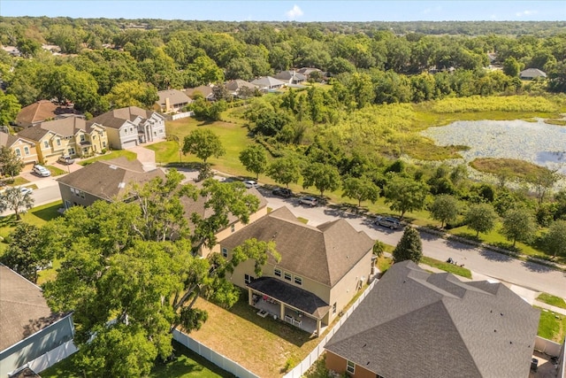 drone / aerial view featuring a water view, a view of trees, and a residential view