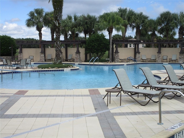 community pool with a patio and fence
