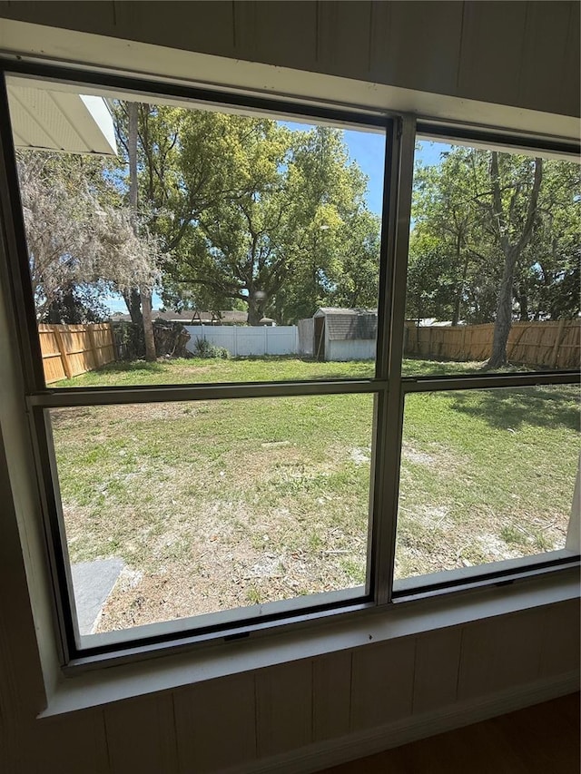 view of yard with a fenced backyard, an outdoor structure, and a storage shed