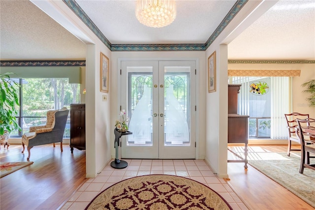 8 Trilby Br, Longwood, FL 32779 - entrance foyer with baseboards, a chandelier, french doors, a textured ceiling, and light tile patterned flooring