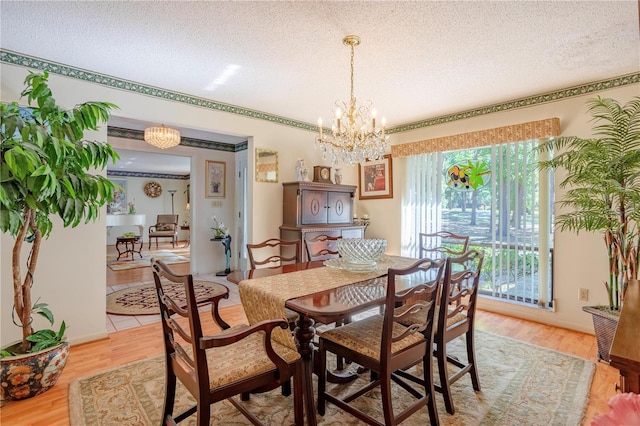 8 Trilby Br, Longwood, FL 32779 - dining room featuring light wood-style floors, a textured ceiling, and an inviting chandelier