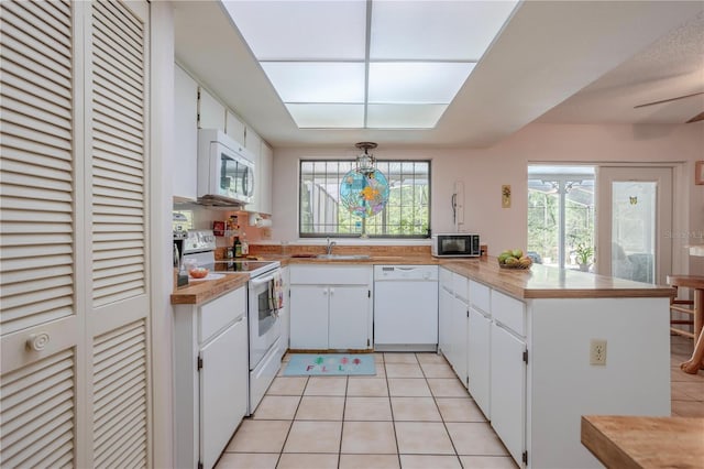 8 Trilby Br, Longwood, FL 32779 - kitchen with white appliances, a peninsula, light countertops, and light tile patterned floors