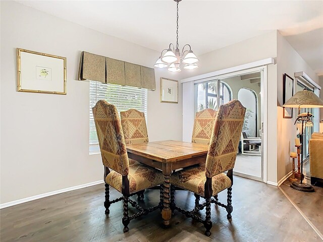 dining room with a chandelier, wood finished floors, and baseboards