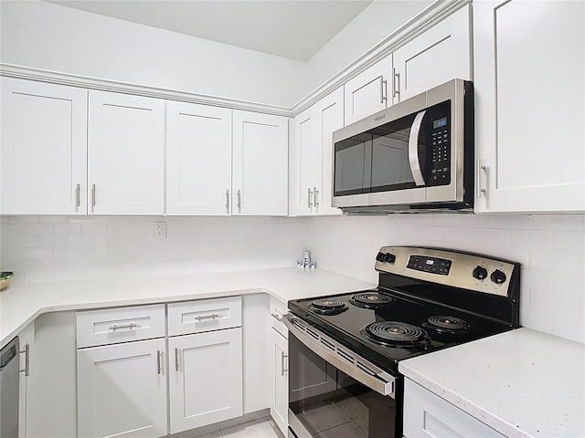 kitchen with appliances with stainless steel finishes, light countertops, white cabinets, and backsplash
