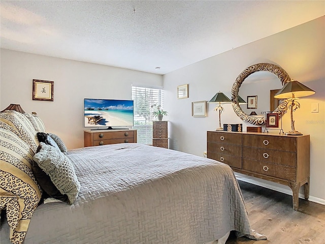 bedroom featuring wood finished floors and a textured ceiling