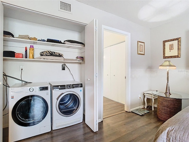 washroom featuring washer and dryer, dark wood finished floors, and baseboards