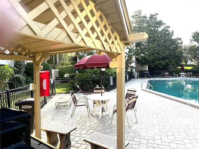 community pool with fence and a patio