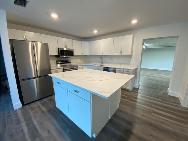 545 Brooks Ct, Polk City, FL 33868 - kitchen featuring a center island, dark wood-style floors, a sink, white cabinetry, and appliances with stainless steel finishes