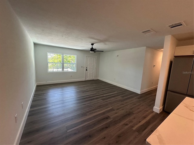 545 Brooks Ct, Polk City, FL 33868 - unfurnished living room with a textured ceiling, ceiling fan, visible vents, baseboards, and dark wood-style floors