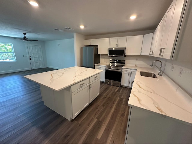 545 Brooks Ct, Polk City, FL 33868 - kitchen with stainless steel appliances, visible vents, a sink, dark wood-type flooring, and a center island
