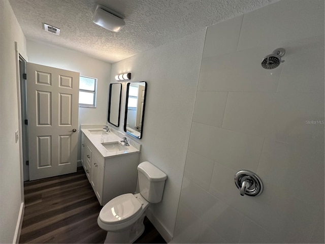 545 Brooks Ct, Polk City, FL 33868 - bathroom featuring a tile shower, wood finished floors, a sink, and a textured ceiling