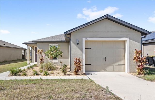 single story home with a garage, driveway, and stucco siding
