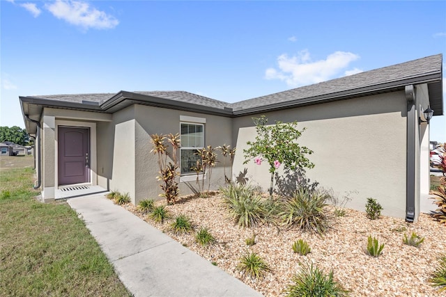 392 Kensington View Dr, Winter Haven, FL 33880 - view of front facade with stucco siding, a shingled roof, and a garage