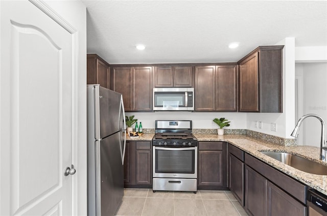392 Kensington View Dr, Winter Haven, FL 33880 - kitchen featuring light tile patterned flooring, light stone countertops, appliances with stainless steel finishes, and a sink