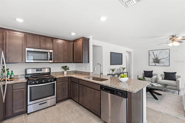 392 Kensington View Dr, Winter Haven, FL 33880 - kitchen with a sink, light tile patterned flooring, stainless steel appliances, a peninsula, and visible vents