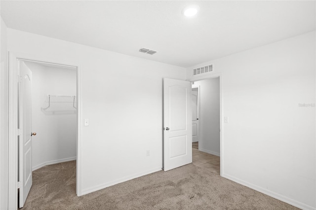392 Kensington View Dr, Winter Haven, FL 33880 - unfurnished bedroom with light carpet, visible vents, a spacious closet, and a closet