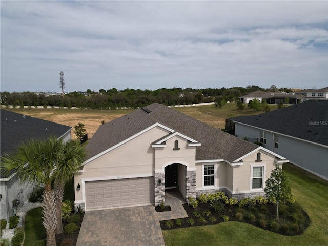 3330 Hanging Tide St, Winter Garden, FL 34787 - single story home featuring a shingled roof, stucco siding, driveway, stone siding, and a garage