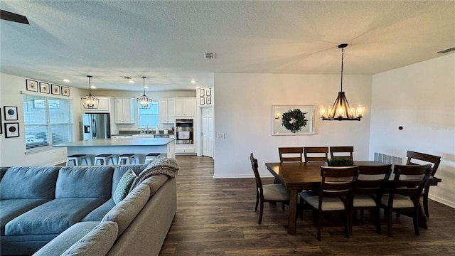 3330 Hanging Tide St, Winter Garden, FL 34787 - dining area featuring a textured ceiling, dark wood finished floors, baseboards, a notable chandelier, and visible vents