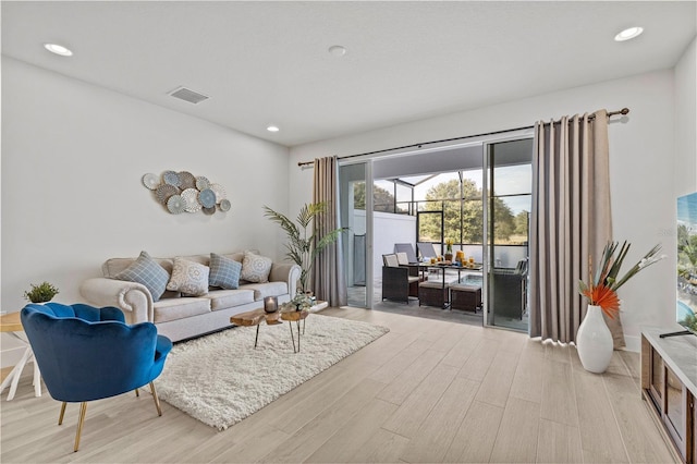 living area featuring recessed lighting, light wood finished floors, and visible vents