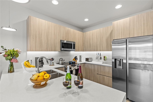kitchen with modern cabinets, light brown cabinetry, and stainless steel appliances