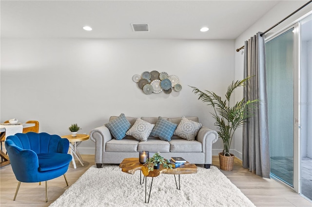 living area with recessed lighting, baseboards, and light wood finished floors