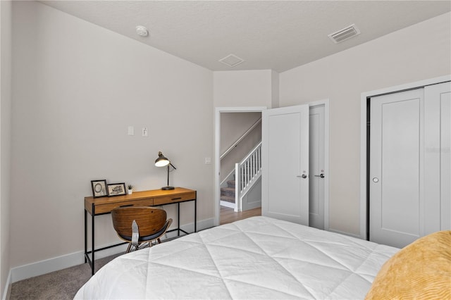 bedroom featuring carpet flooring, baseboards, visible vents, and multiple closets