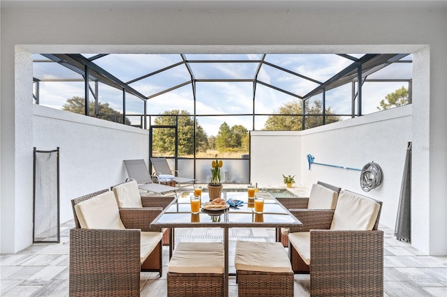 view of patio featuring outdoor dining area and a lanai