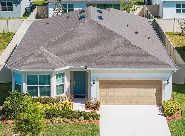 4012 Meandering Bay Dr, Apopka, FL 32712 - view of front of property featuring roof with shingles, an attached garage, concrete driveway, and fence