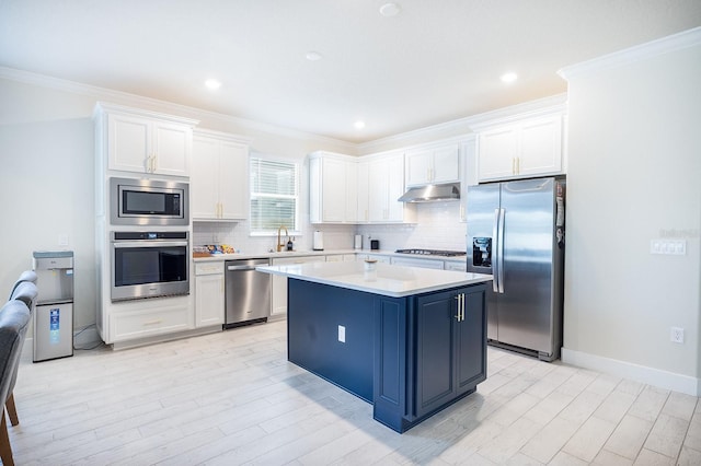 4012 Meandering Bay Dr, Apopka, FL 32712 - kitchen with appliances with stainless steel finishes, under cabinet range hood, a sink, white cabinets, and crown molding