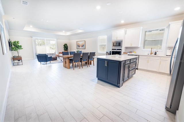 4012 Meandering Bay Dr, Apopka, FL 32712 - kitchen featuring stainless steel appliances, white cabinetry, crown molding, light countertops, and decorative backsplash