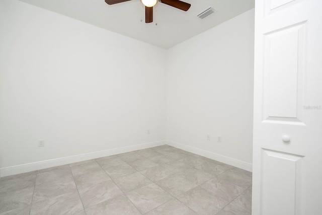 spare room with baseboards, a ceiling fan, and visible vents
