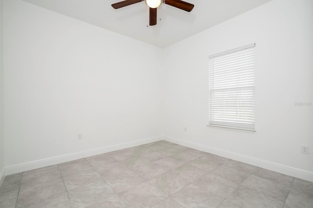 spare room featuring baseboards and a ceiling fan