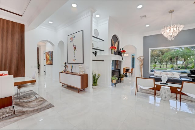 interior space featuring crown molding, arched walkways, and an inviting chandelier