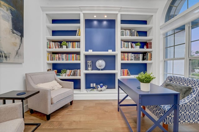 living area with wood finished floors and built in shelves