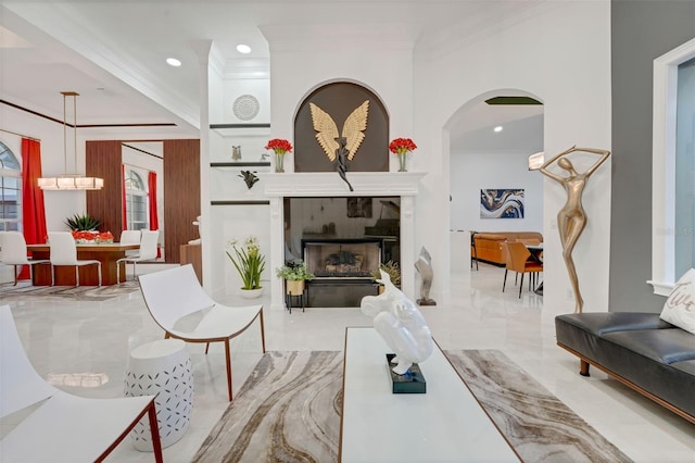 living room featuring ornamental molding, a fireplace, recessed lighting, arched walkways, and marble finish floor