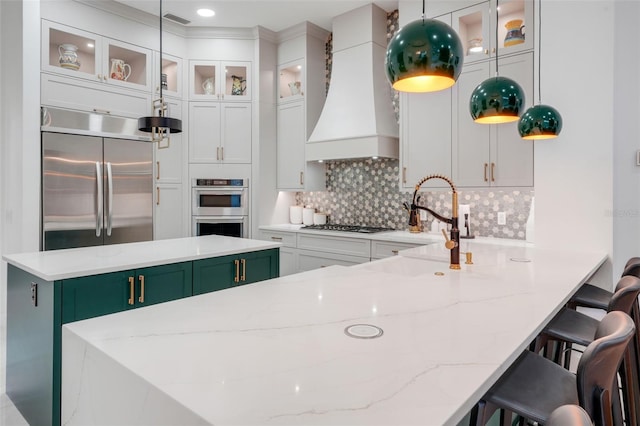 kitchen featuring custom exhaust hood, backsplash, white cabinets, visible vents, and appliances with stainless steel finishes