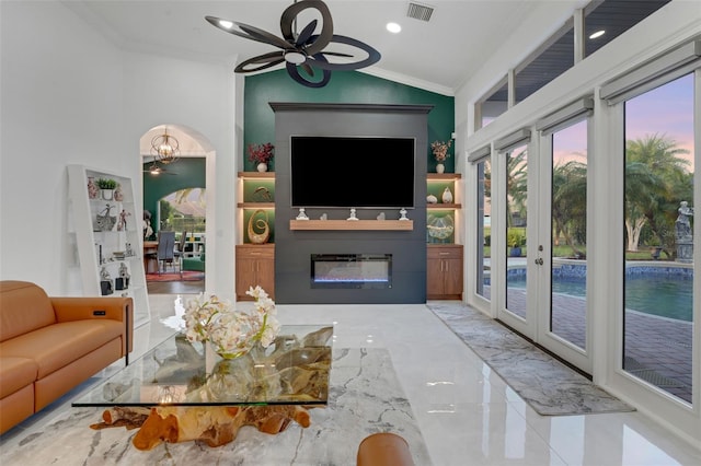 living area with a glass covered fireplace, french doors, crown molding, visible vents, and lofted ceiling