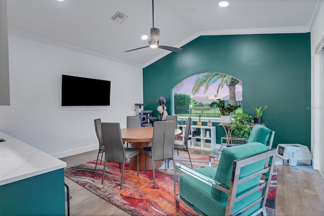 dining room featuring baseboards, crown molding, a ceiling fan, lofted ceiling, and wood finished floors