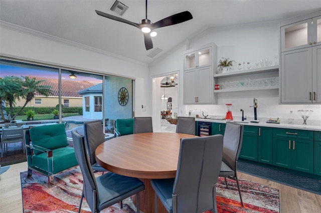 dining area with visible vents, light wood-type flooring, vaulted ceiling, and ceiling fan