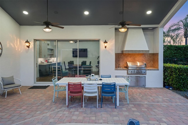view of patio / terrace with grilling area, a ceiling fan, outdoor dining area, and an outdoor kitchen